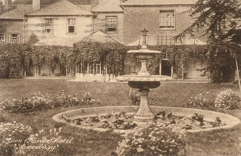 An old sepia photograph of the garden fountain in front of the ivy-covered house, captioned Avon (Private) Hotel, Amesbury