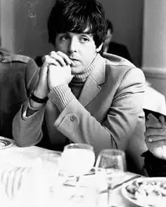 Paul McCartney at a table at the hotel in 1965, his hands clasped under his chin