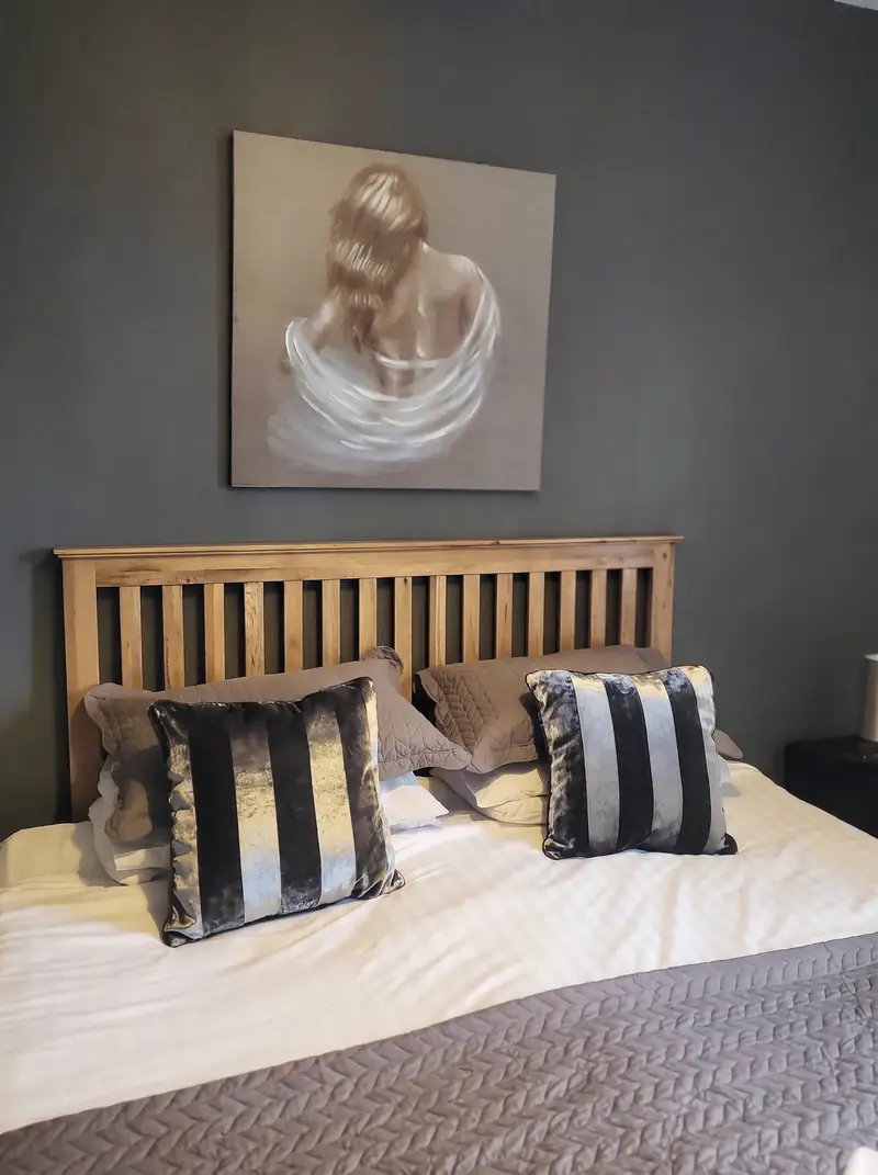 A double room with an oak bedstead and striped cushions