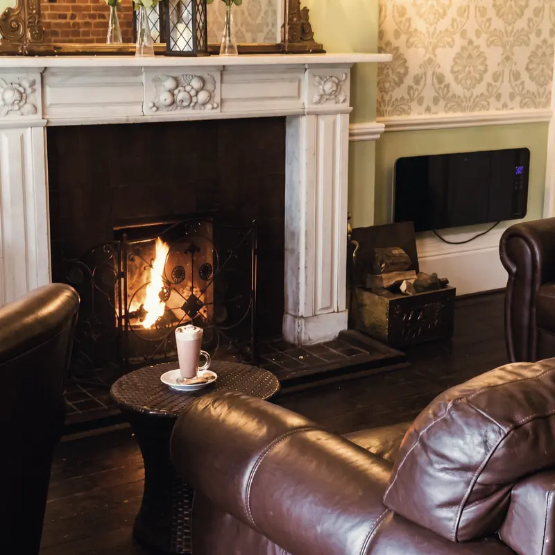 A cup of coffee on a small table beside the open fire