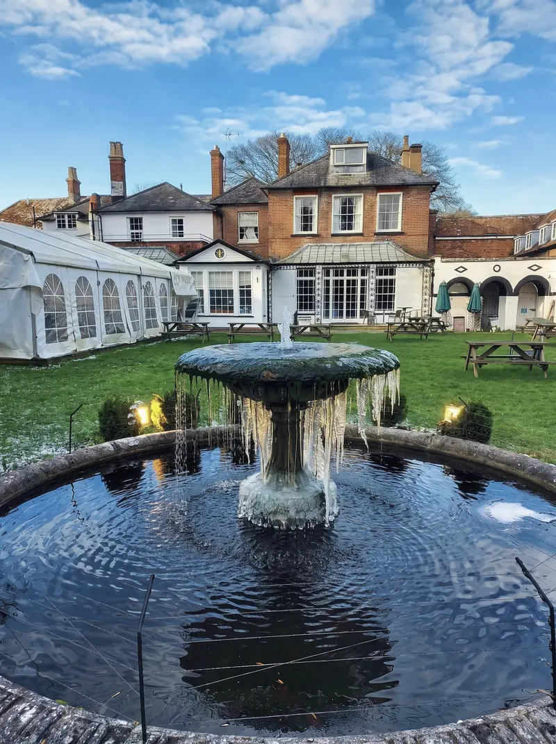 The garden fountain running, with the marquee and the back of the hotel behind it