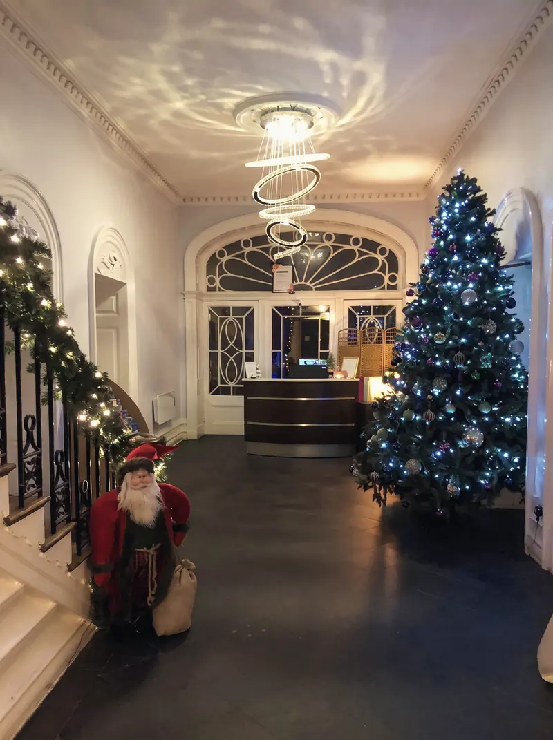 The entrance hall and staircase decorated with a Christmas tree and garlands