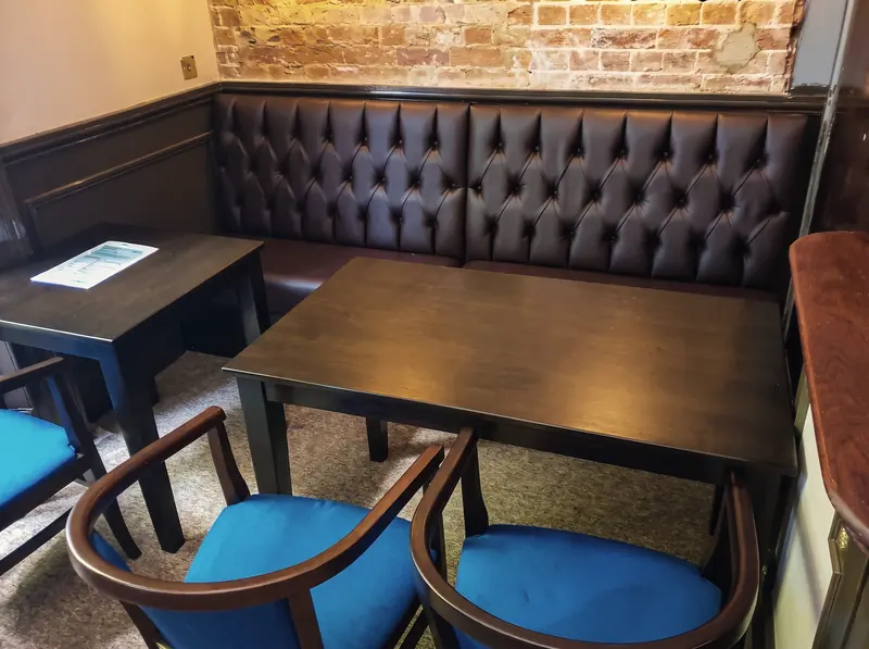 Buttoned leather booth seating and blue armchairs in the lounge bar