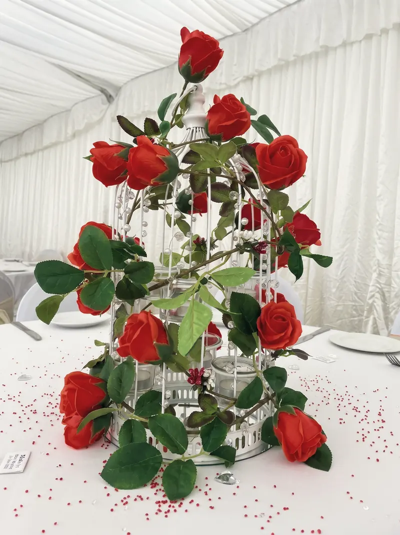 A table centrepiece of red roses inside the marquee